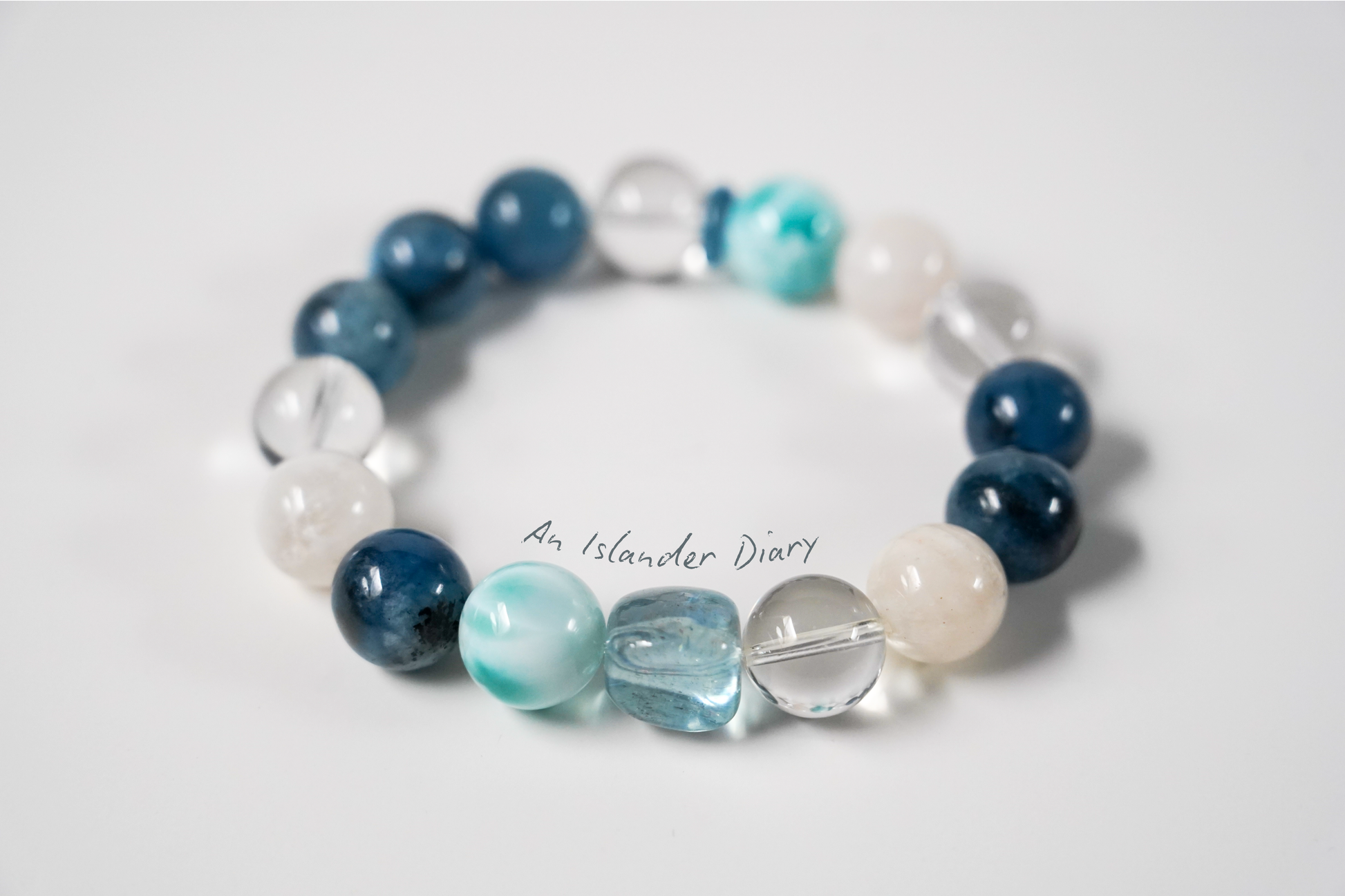 Beaded crystal bracelet with blue, white, and clear beads on a light gray background