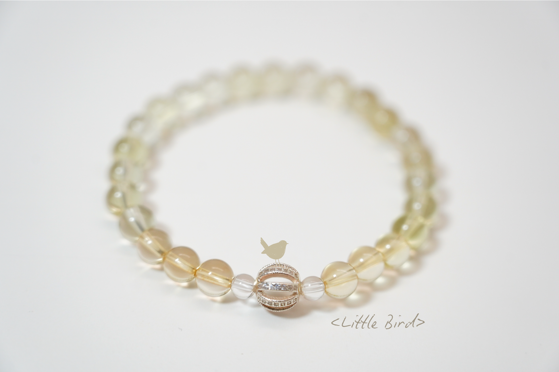 Beaded crystal bracelet with a clear charm on a light gray background