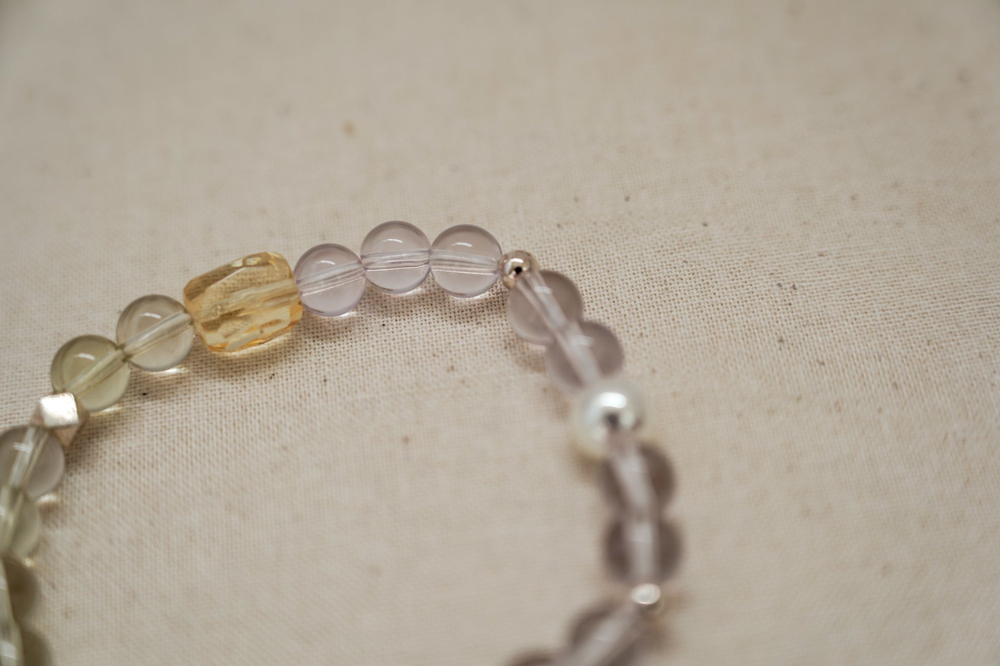 Close-up of a crystal beaded bracelet on a beige fabric background