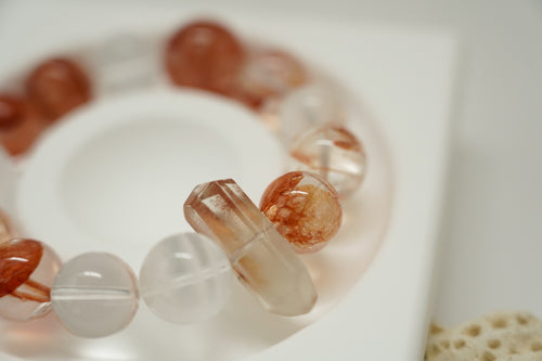 Close-up of Amber Dawn Crystal Bracelet with peach-colored beads on a white background