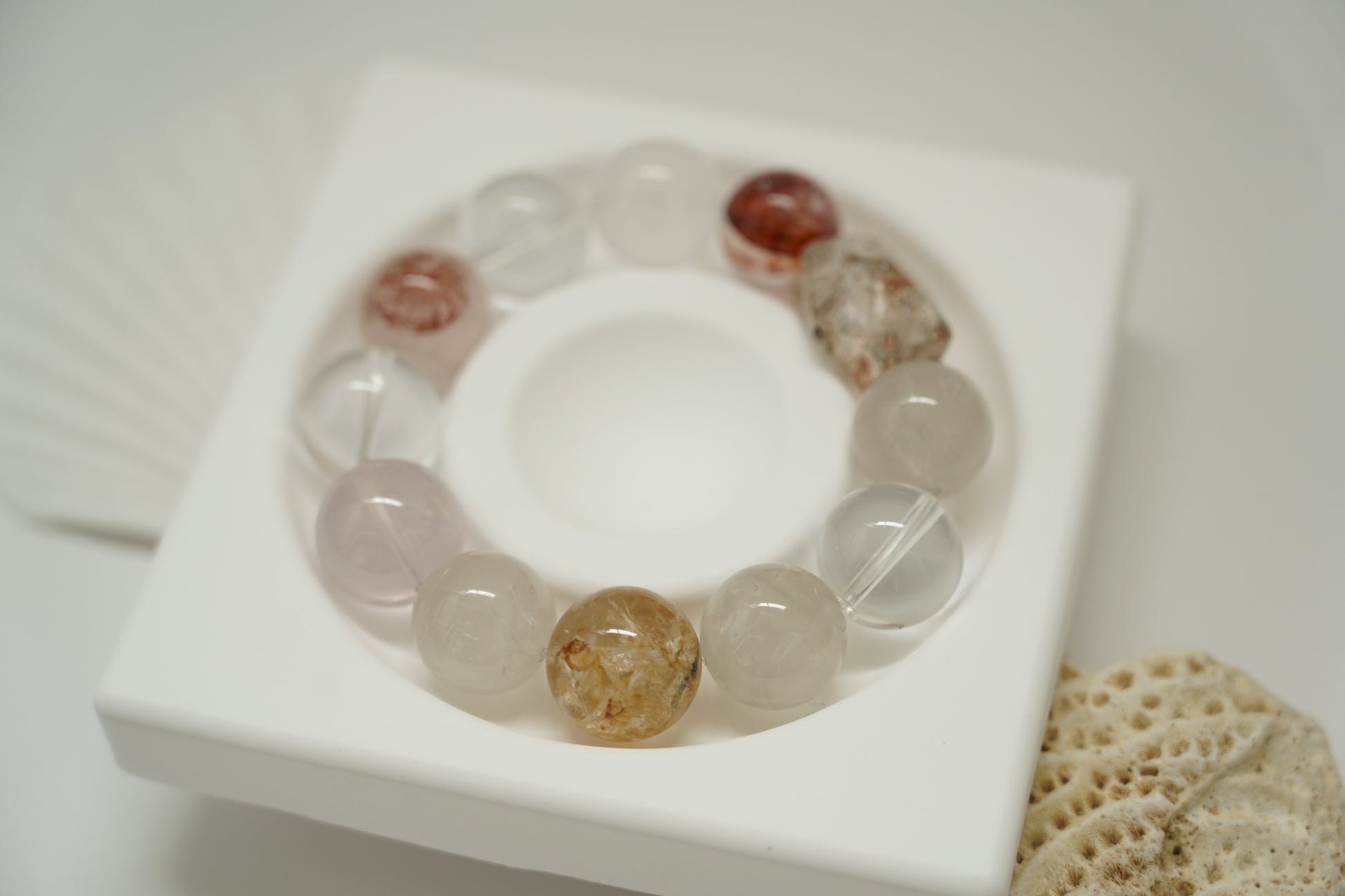 Crystal bracelet on a white tray with a neutral background