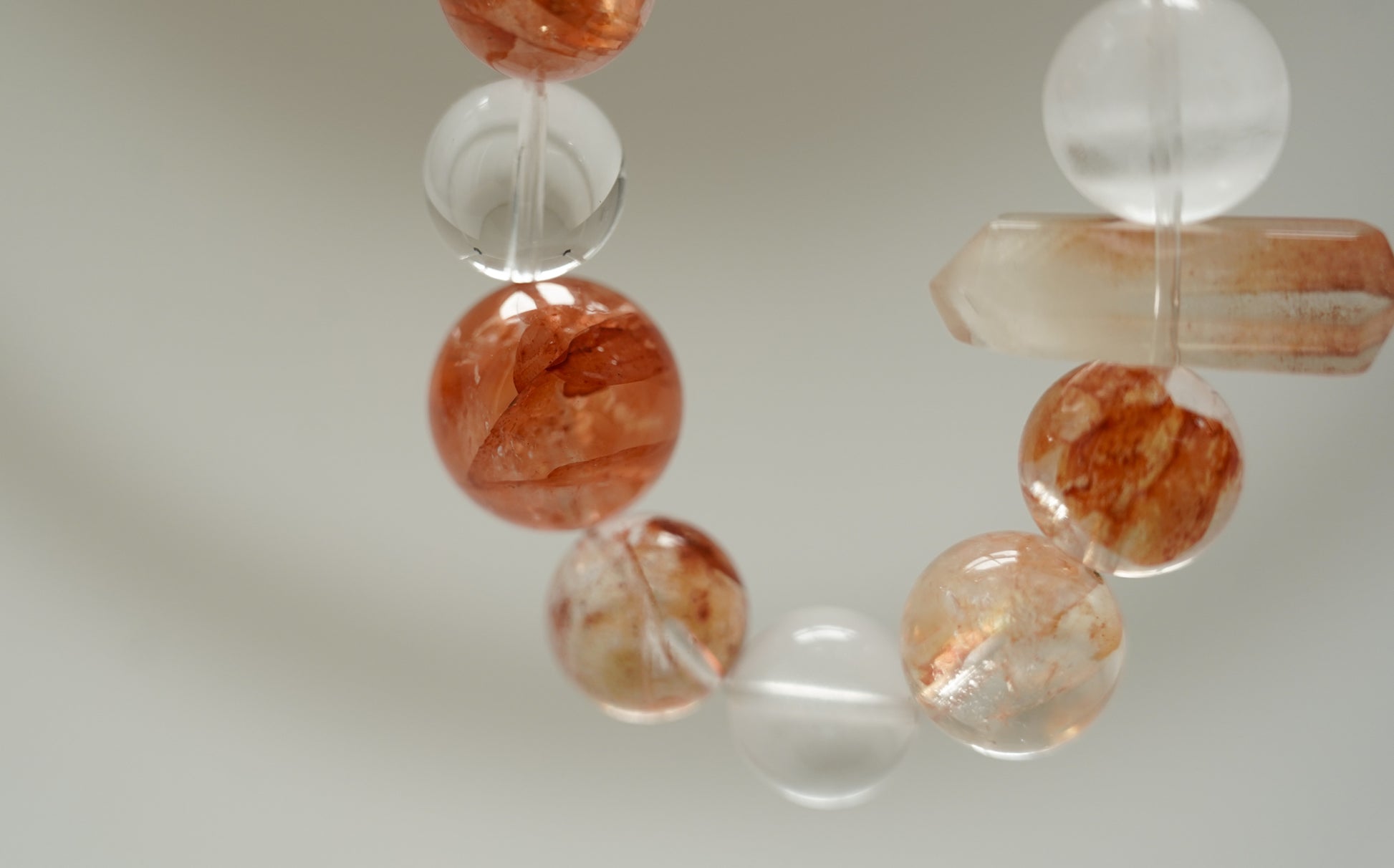 Close-up of Amber Dawn Crystal Bracelet with orange and clear beads on a neutral background